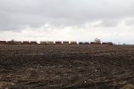 Across the barren fall fields, BNSF 4195 leads S-LPCLBT1 west